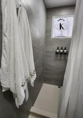 a bathroom with white towels hanging on a wall at Serene Summer close proximity to Araneta Centre in Manila