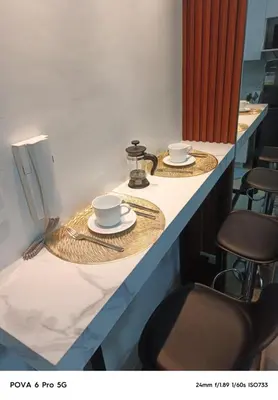two cups and plates on a counter with chairs at Mitch serene shore in Manila