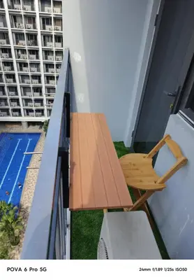 a wooden bench on the balcony of a building at Mitch serene shore in Manila
