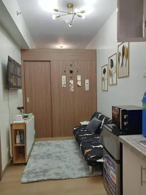 a living room with a couch in a kitchen at Spring Residences 2BR R&D Staycation and Condotel in Manila