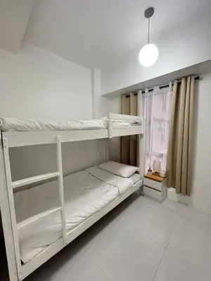 a room with two bunk beds and a window at Lucky 7 Suites in Manila