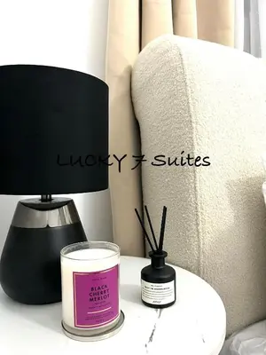 a candle and a lamp on a table next to a couch at Lucky 7 Suites in Manila