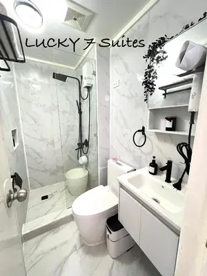 a bathroom with a toilet and a shower and a sink at Lucky 7 Suites in Manila