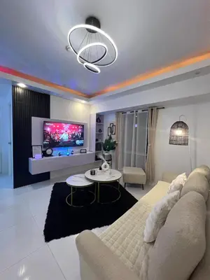 a living room with a couch and a tv at Lucky 7 Suites in Manila