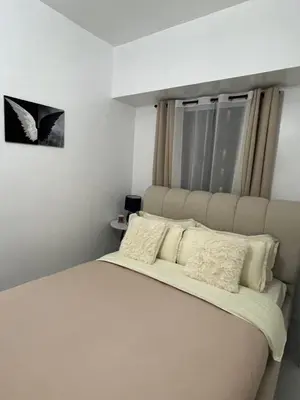 a bedroom with a large bed with white pillows at Lucky 7 Suites in Manila