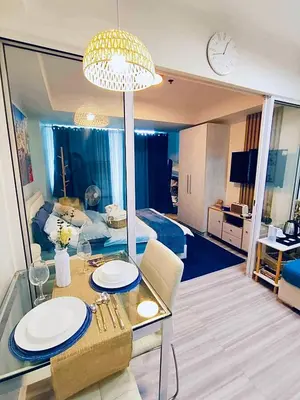 a living room with a table and a dining room at Oveecation Suites St Tropez Tower in Manila