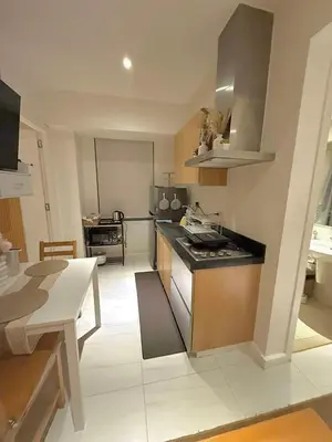 a kitchen with a stove and a table in it at Oveecation Suites Positano Tower in Manila
