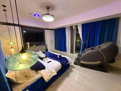 a bedroom with a bed with a table and a chair at Oveecation Suites Positano Smarthome in Manila