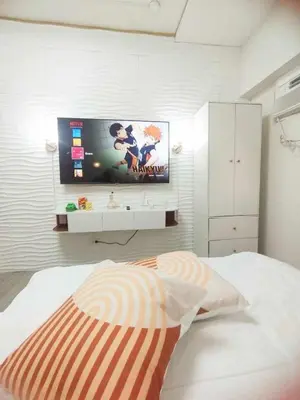 a bedroom with a bed with a tv on the wall at Condo in Las Piñas- The Suite Spot Alabang in Manila