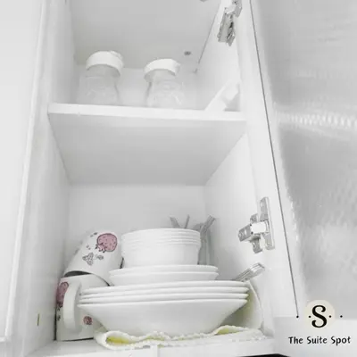 a white cabinet with bowls and plates in it at Condo in Las Piñas- The Suite Spot Alabang in Manila