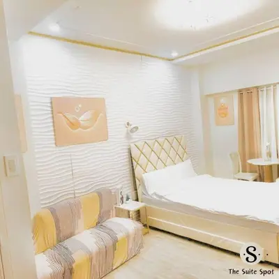 a white room with two beds and a table at Condo in Las Piñas- The Suite Spot Alabang in Manila