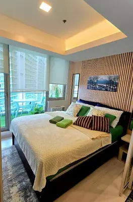 a large bedroom with a large bed with green pillows at Urban Resort luxury Staycation at Azure Residences Rio Tower in Manila