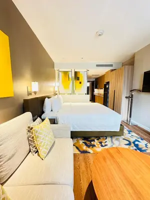a hotel room with two beds and a couch at Hotel Residences near Makati in Manila