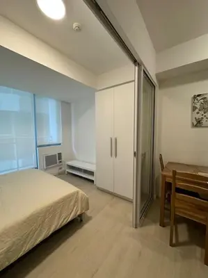 a bedroom with a bed and a table and a desk at Dwell in Manila