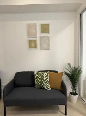 a black couch in a living room with a plant at Dwell in Manila