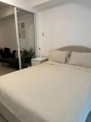 a bedroom with a large white bed in a room at Dwell in Manila