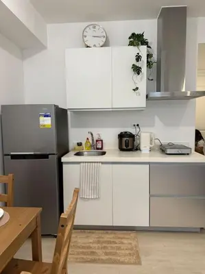 a kitchen with white cabinets and a clock on the wall at Dwell in Manila