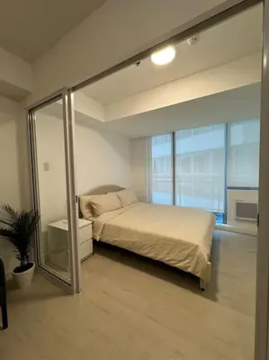 a bedroom with a bed and a sliding glass door at Dwell in Manila