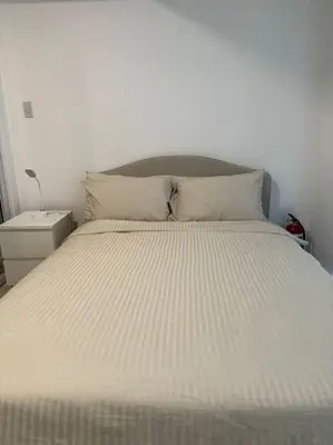 a bed with white sheets and pillows in a bedroom at Dwell in Manila