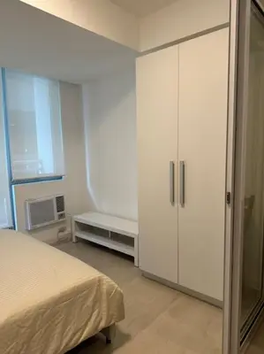 a bedroom with a bed and a white cabinet at Dwell in Manila