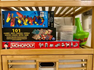 a wooden shelf with toys and games on it at Azure Urban Resort Residences Maui Tower in Manila