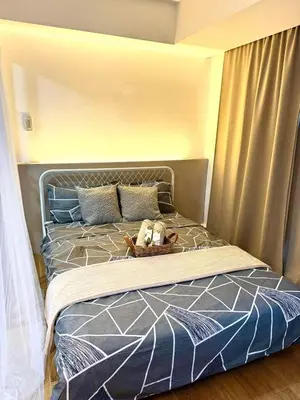 a bed with a teddy bear in a basket on it at Azure Urban Resort Residences Maui Tower in Manila
