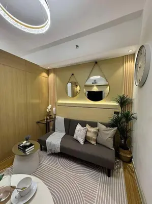 a bedroom with a bed and a clock on the wall at Taguig - Modern Luxe at Grace Residences in Manila