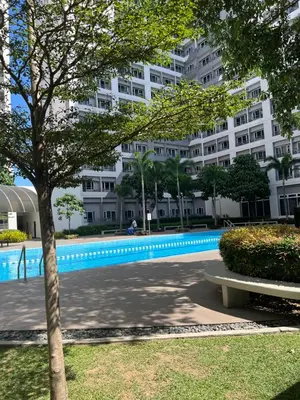 a swimming pool in front of a large building at Taguig - Modern Luxe at Grace Residences in Manila