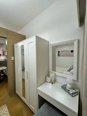 a room with a white cabinet with a mirror at Taguig - Modern Luxe at Grace Residences in Manila