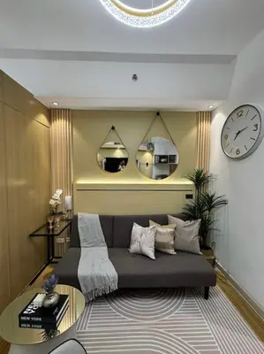 a bedroom with a bed and a clock on the wall at Taguig - Modern Luxe at Grace Residences in Manila