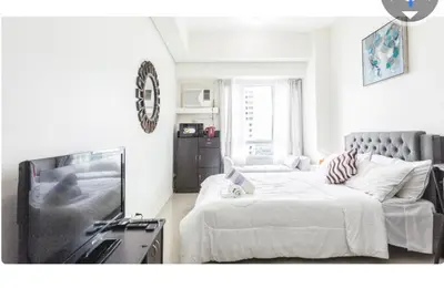 a living room with a bed and a tv at Makati Beacon Studio Suite in Manila