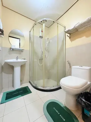 a bathroom with a shower and a toilet and a sink at Makati Beacon Studio Suite in Manila