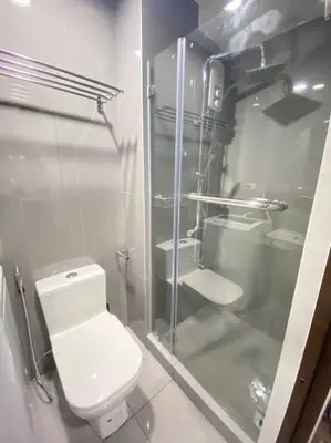 a bathroom with a toilet and a glass shower at AIR RESIDENCES Makati Netflix plus 200 mbps digital door lock in Manila