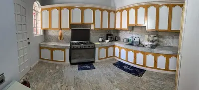 a kitchen with wooden cabinets and a stove at Tropical house in Manila
