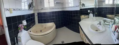 a bathroom with a tub and a toilet and a sink at Tropical house in Manila