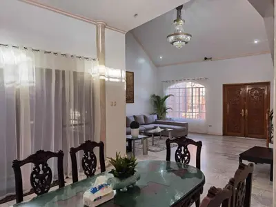 a living room with a table and chairs and a couch at Tropical house in Manila