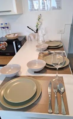 a table with plates and silverware on a counter at Luxury Bohemian Suite Venice Canal Mall & BGC Views in Manila