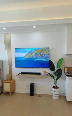 a living room with a flat screen tv on a wall at Luxury Bohemian Suite Venice Canal Mall & BGC Views in Manila
