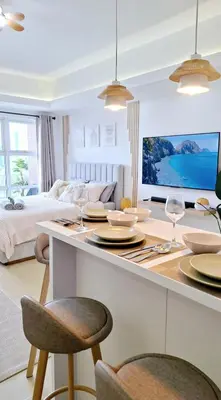 a living room with a bed and a table with wine glasses at Luxury Bohemian Suite Venice Canal Mall & BGC Views in Manila