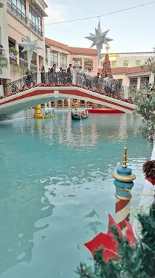 a group of people standing on a bridge over a river at Luxury Bohemian Suite Venice Canal Mall & BGC Views in Manila