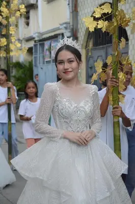 a woman in a white dress holding a pole at Aura Suites in Imus