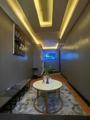 a room with a table and chairs and a ceiling at Aura Suites in Imus