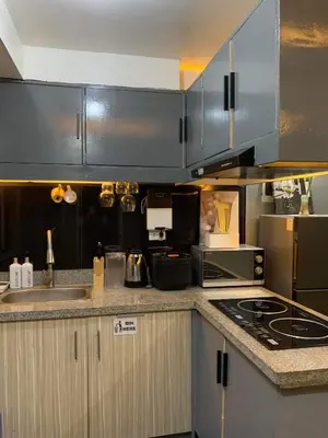 a kitchen with a sink and a stove top oven at Aura Suites in Imus