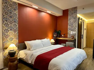 a bedroom with a large bed with a red wall at Prime End Sunset View Unit in Makati in Manila