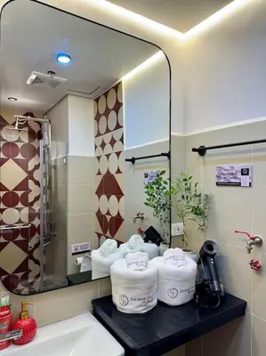 a bathroom with a sink and a mirror and towels at Prime End Sunset View Unit in Makati in Manila