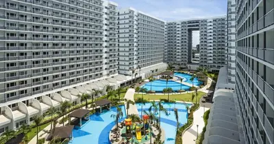 an aerial view of a resort with two pools and buildings at Cozy Staycation by Ayumi in Manila