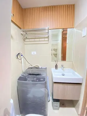 a bathroom with a sink and a toilet and a mirror at Comfystay at Shore Residences in Manila