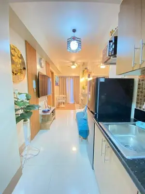 a kitchen with a sink and a refrigerator at Comfystay at Shore Residences in Manila