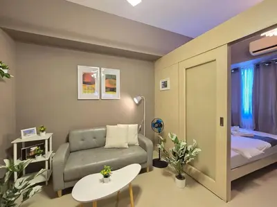 a small living room with a couch and a bed at 1BR Condotel with Balcony at SM Light Residences #LT10 in Manila