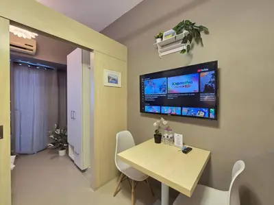 a room with a table and a tv on the wall at 1BR Condotel with Balcony at SM Light Residences #LT10 in Manila